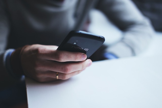 スマホを持つ人の画像
