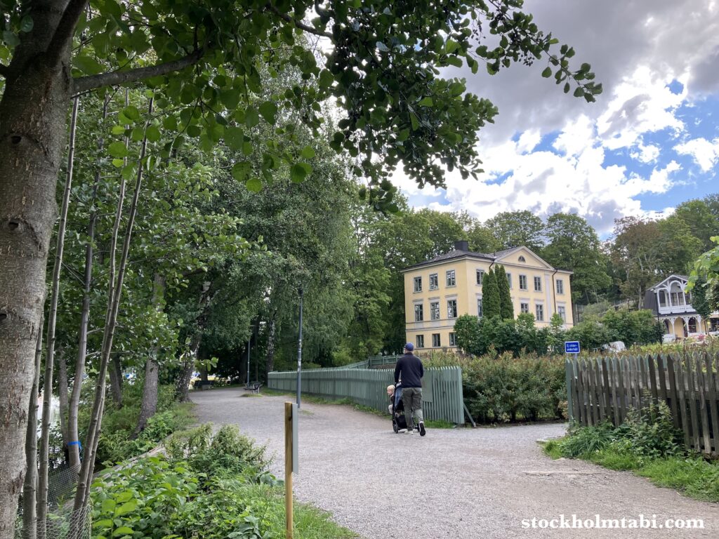 Karlbergssjön沿いの散歩道とベービーカーを押す男性